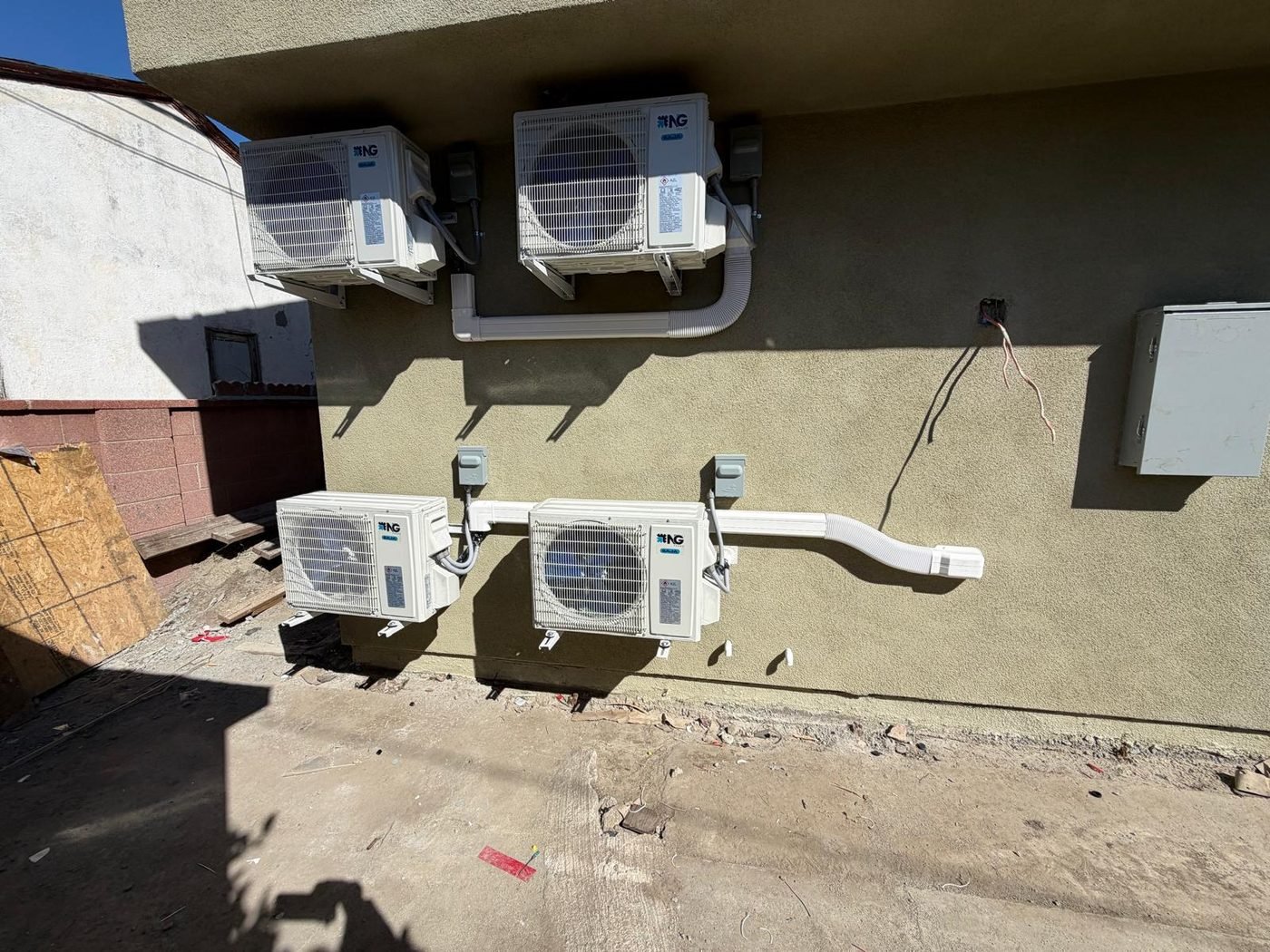Four mini-split condenser units mounted on exterior wall